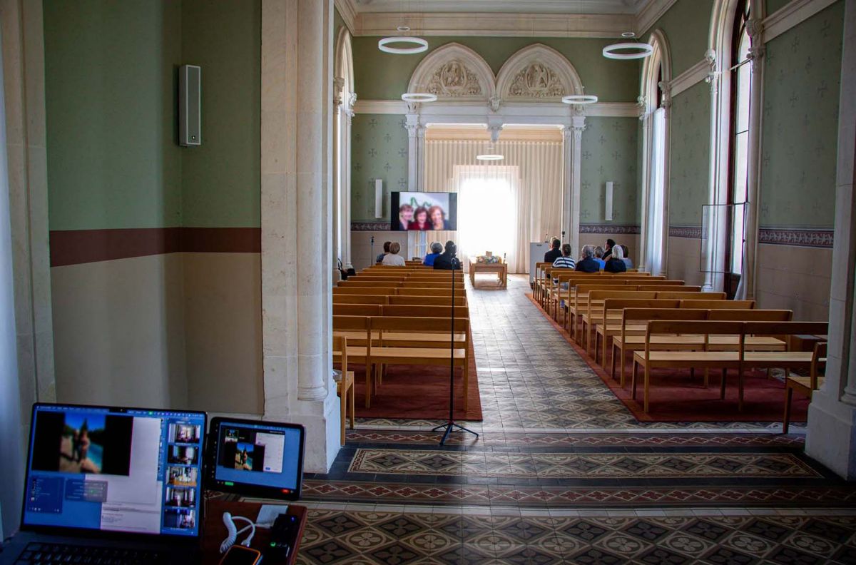 Memorial chapel with a portrait shown on screen during a live-streamed ceremony
