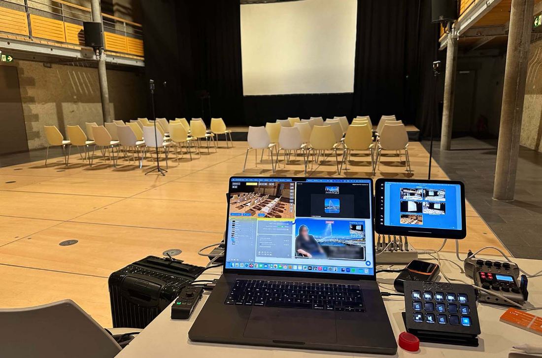 Live streaming station with laptop and tablets set up in a ceremony hall